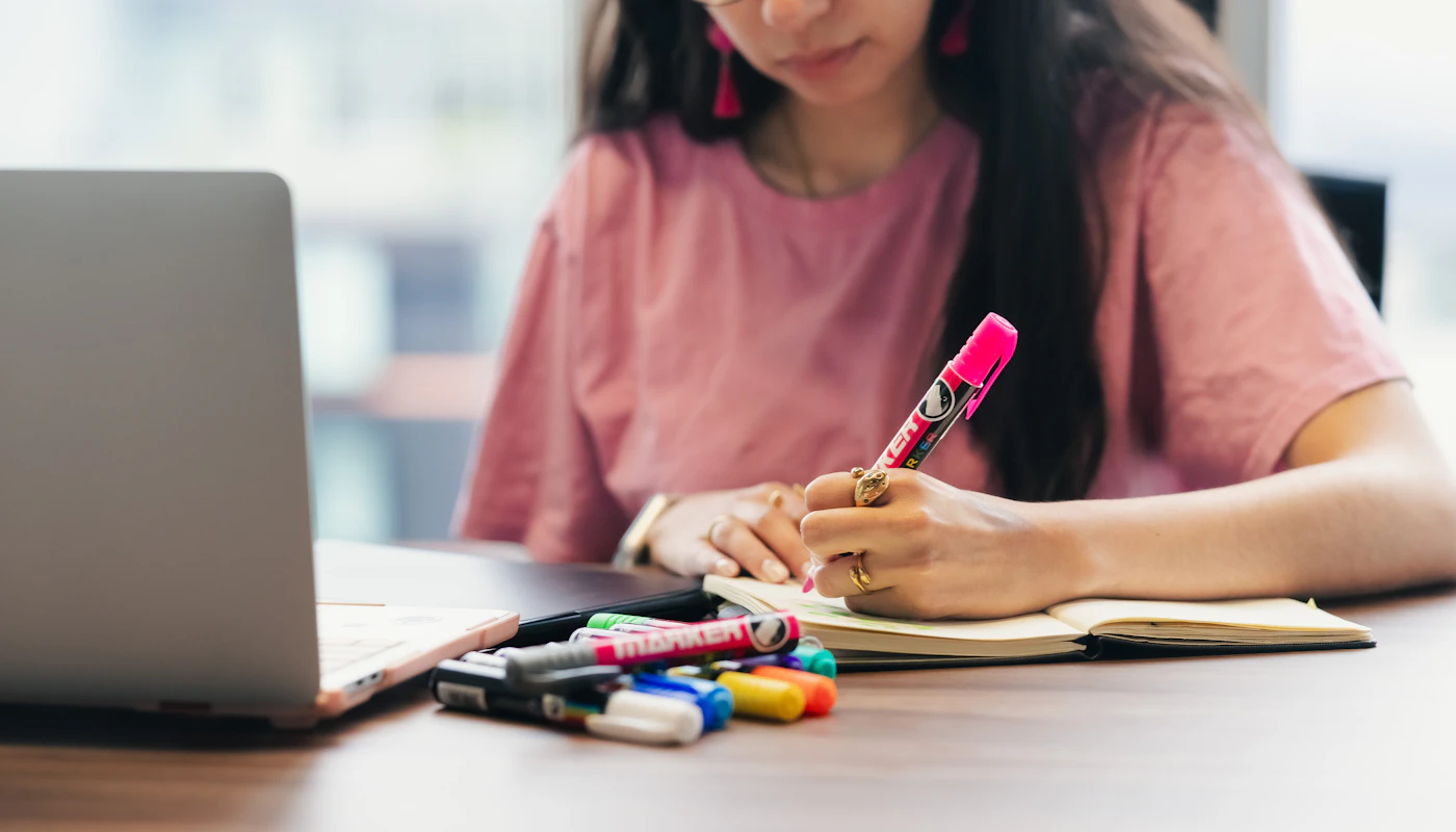 Candidate qui révise l’examen VTC avec un ordinateur et un carnet